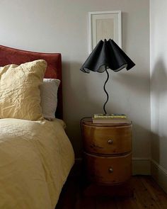 a bedroom with a bed, nightstand and lamp