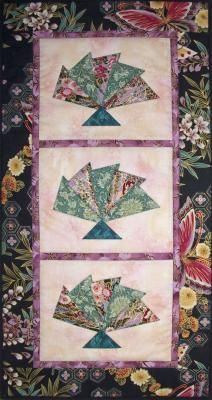 three quilts with flowers on them and one has an origami fan in the middle