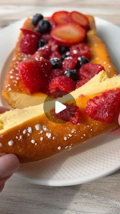 a person holding a piece of bread with fruit on it