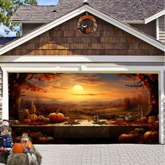 a garage with a painting on the side of it and pumpkins in front of it