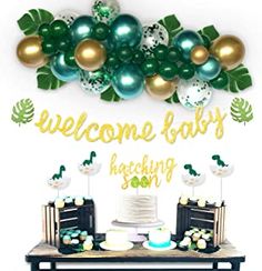 a welcome baby backdrop with balloons and cake