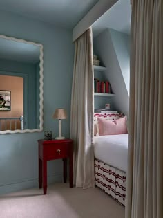 a bedroom with blue walls and a red table in front of the bed is shown