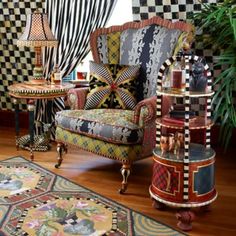 a living room filled with lots of furniture next to a rug and window covered in black and white checkered curtains