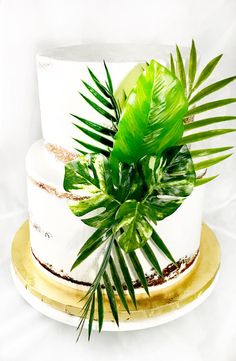 a white cake with green leaves on top