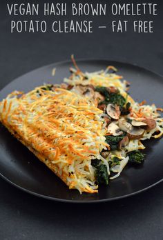 a black plate topped with an omelette covered in cheese