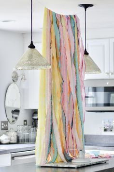 two lamps hanging from the ceiling in a kitchen