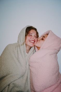 two women wrapped in blankets are smiling at the camera