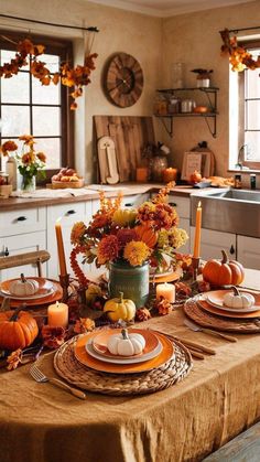 a table set for thanksgiving dinner with pumpkins and gourds in the center