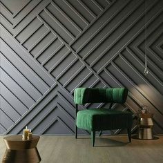 a green chair sitting in front of a wall with geometric designs on it's sides