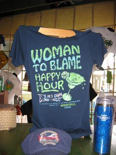 a t - shirt that says woman to blame happy hour sits on a table