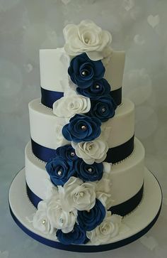 a three tiered wedding cake with blue and white flowers