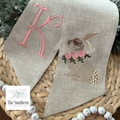 two linen buntings decorated with pink flowers and monogrammed letters