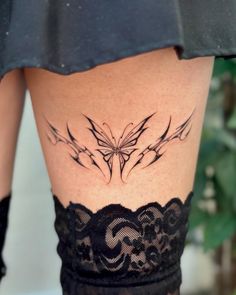 a woman's thigh with tattoos on it