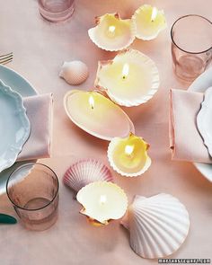 the table is set with plates, silverware and seashells for an elegant dinner