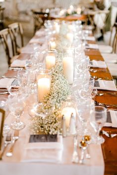 a long table is set with candles and place settings