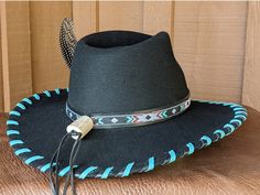 The Twilight felt hat is 100% wool and has a 3.5" brim and 4.25" crown. Hand laced in black and turquoise leather lace. The black leather band features hitched webbing. Decorative large turquoise Concho and Guinea feather completes the hat. Note: All hats are made to order. Please allow up to 4 weeks for your hat to ship. Black Felt Hat With Flat Crown For Ranch, Black Felt Hat With Flat Crown For Country Events, Black Southwestern Style Hat For Festival, Southwestern Style Black Hat For Festivals, Black Southwestern Style Festival Hat, Southwestern Black Hat Bands For Country Events, Custom Black Brimmed Felt Hat, Custom Black Felt Hat For Western-themed Events, Southwestern Black Hat With Short Brim