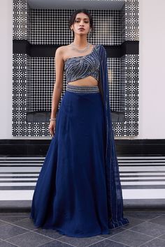 Electric blue one shoulder embroidered blouse with linear work and embellished side palla blouse. Comes with lehenga with slit and embroidered waistband.
Component: 2
Pattern: Embroidered
Type Of Work: Linear
Neckline: Asymmetric
Sleeve Type: One side draped
Fabric: Blouse: Silk, Lehenga: Organza
Color: Blue
Other Details: 
Linear embroidery
Asymmetric neckline
Note: The neckpiece worn by the model is not for sale
Occasion: Sangeet - Aza Fashions One Sided Blouse Design, One Side Sleeve Blouse Lehenga, One Side Blouse Designs, One Side Sleeve Blouse, Blue Sangeet Outfit, One Side Shoulder Blouse, Sangeet Outfit For Bridesmaid, One Shoulder Lehenga, Lines Embroidery