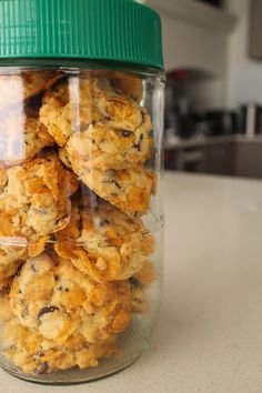 a glass jar filled with cookies sitting on top of a counter