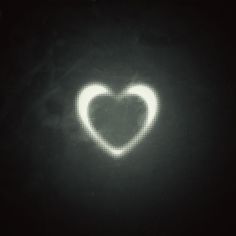 a heart shaped object in the dark with white light coming from it's center