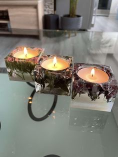 two candles sitting on top of a glass table