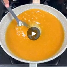 a person stirring a bowl of soup with a spoon