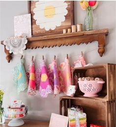 colorful towels hanging on clothes line in front of wooden shelf with flowers and other items