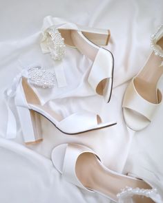 two pairs of white shoes with pearls on them