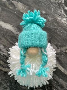 a white and blue knitted hat on top of a rock