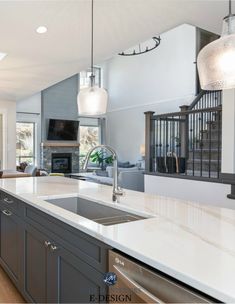 a kitchen with white counter tops and gray cabinets