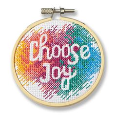 a cross - stitch hoop with the words choose joy on it and an image of a rainbow