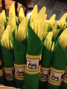 there are many green and yellow paper cones in the basket on the table with forks