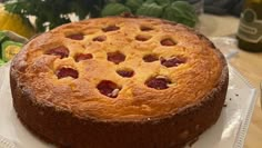 a cake sitting on top of a white plate next to other food and fruit items