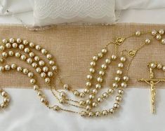 the rosary, bracelet and cross are laid out on the bed