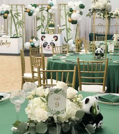 the tables are set up with green linens and white flowers, panda decorations, and balloons