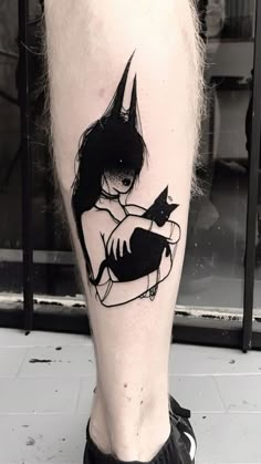 a person with a cat tattoo on their leg