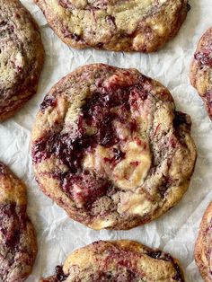 several cookies with cranberry toppings sitting on top of wax paper next to each other