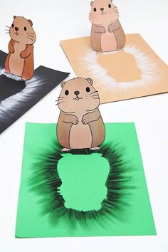 paper cut out of groundhogs on top of green papers