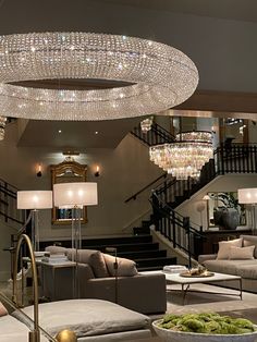 a living room filled with furniture and a chandelier hanging from it's ceiling