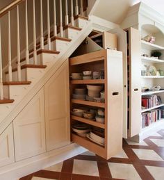 an open cabinet under the stairs in a house