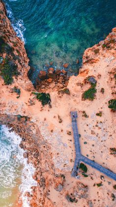 an aerial view of the beach and ocean from above, looking down on the walkway