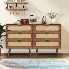 a wooden dresser with wicker drawers and shelves on top of it next to a potted plant