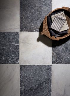 a basket filled with cloths on top of a black and white checkered floor