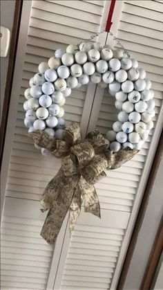 a wreath is hanging on the door with white and blue balls attached to it's front