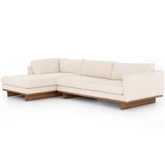 a white sectional couch sitting on top of a wooden frame