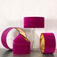 a table topped with pink lamps and vases