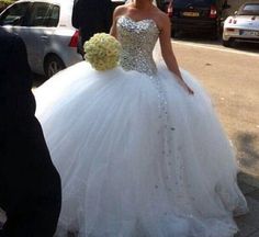 a woman in a wedding dress is walking down the street