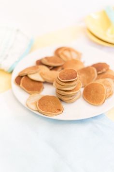 pancakes on a white plate with blue napkins and yellow plates in the back ground