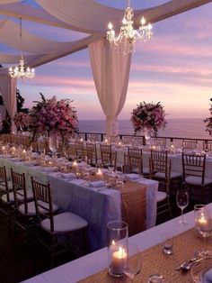 an outdoor dining area with tables and chairs set up for a formal function at dusk