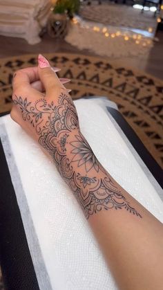 a woman's arm with a tattoo on it sitting on top of a table