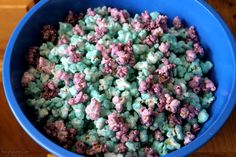 a blue bowl filled with popcorn on top of a wooden table